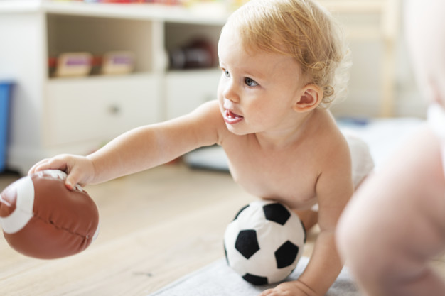 Baby playing with sports balls